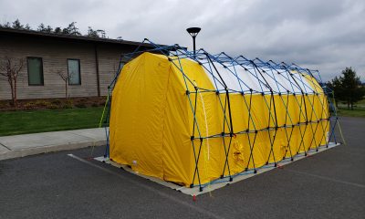 A large yellow tent sits in a parking lot