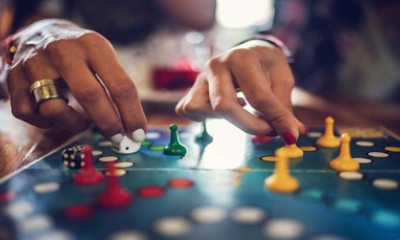 Close-up of two hands moving pawns on a board game