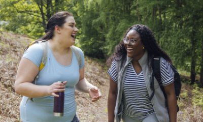 Two women share a laugh while walking outdoors