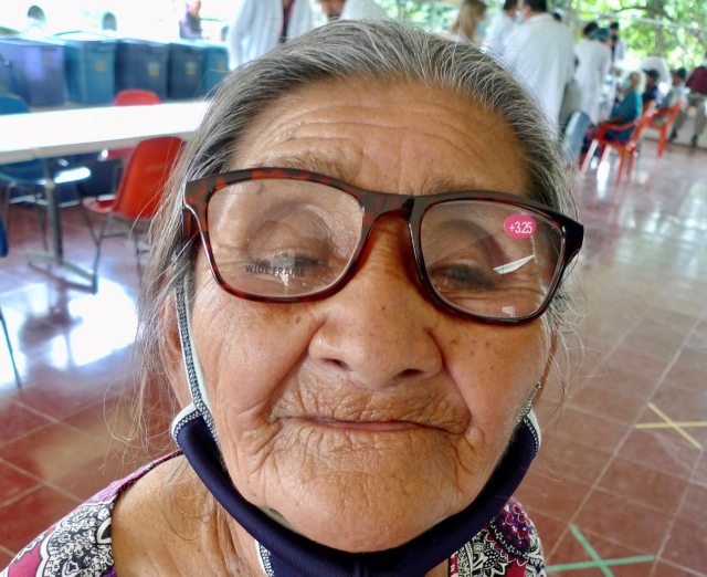 An older lady looking into the camera with her new eyeglasses