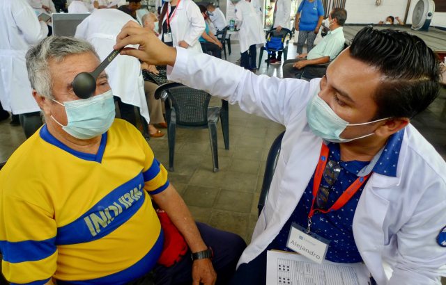 A PeaceHealth provider examines the eyesight of a PazSalud patient