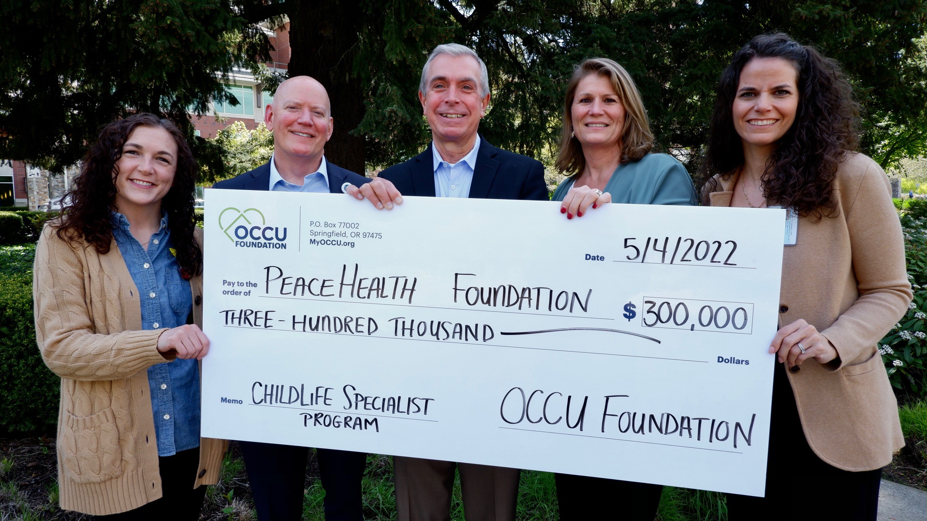 The OCCU Foundation presents PeaceHealth with a large check for the Childlife Specialist Program
