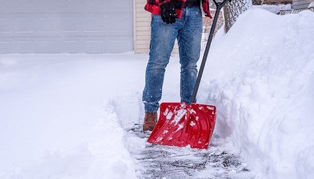 Man shovels snow from driveway