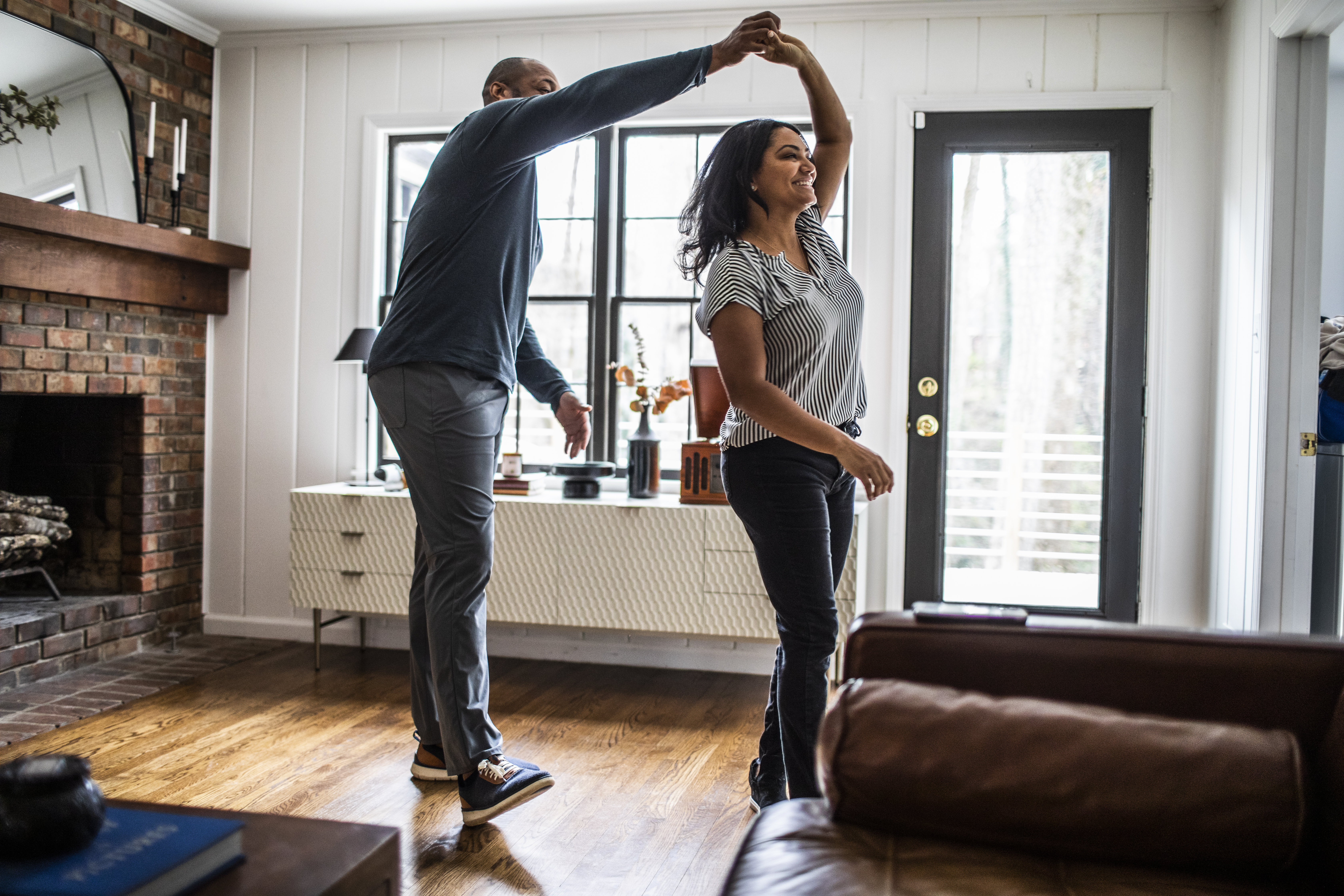 Man and woman dance in a living room
