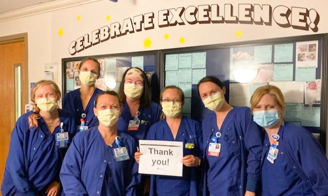 A group of 7 health care providers wih a sign that says "Thank You!"