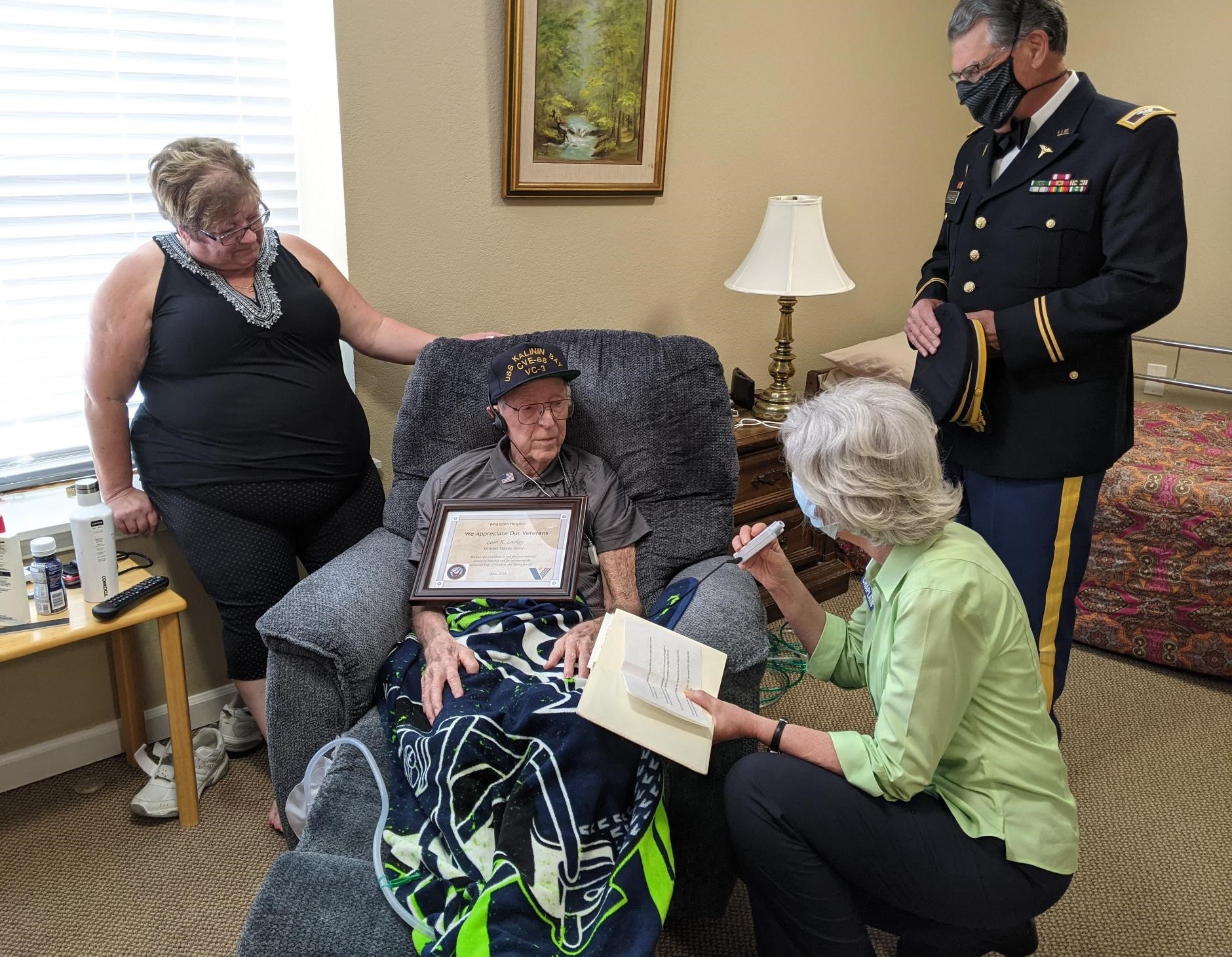 A veteran is given an award and pinned with a medal for his service.