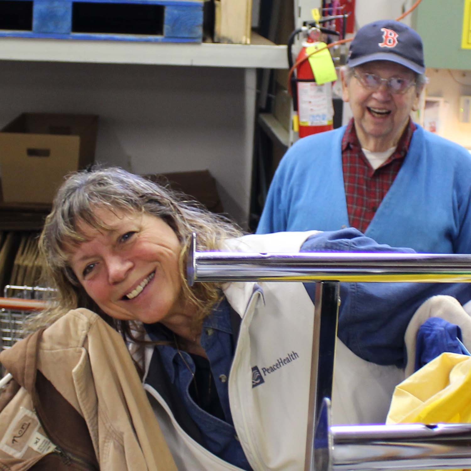 Two PeaceHealth staff members smile and laugh while looking at the camera