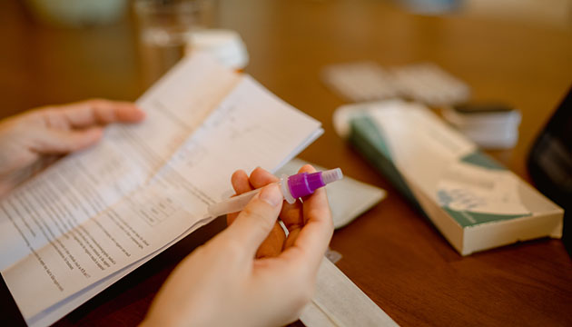 Close up of hands holding a COVID-19 at-home testing kit