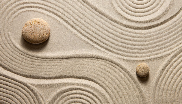 Swirls of sand around rocks in a zen garden