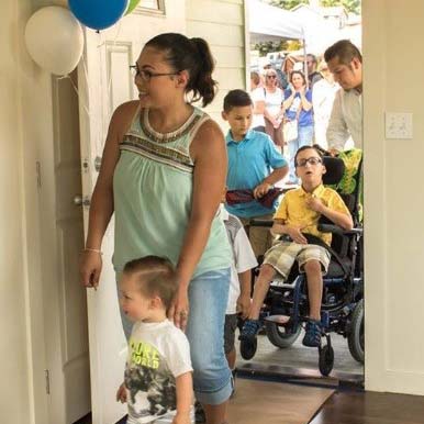 A family walks into a home built by Habitat for Humanity