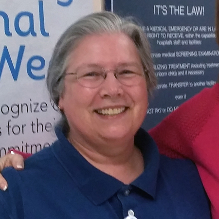 A woman smiling in front of instructional signs