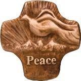 A clay colored plaque with a dove and mountain carving over the word Peace
