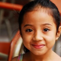 A young Pazsalud girl smiling and looking at the camera