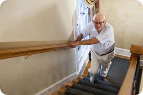 An older man begins his ascent on the stairway