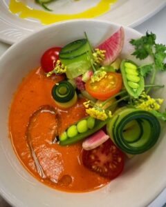 Tomato soup with fresh peas, radishes and other veggies