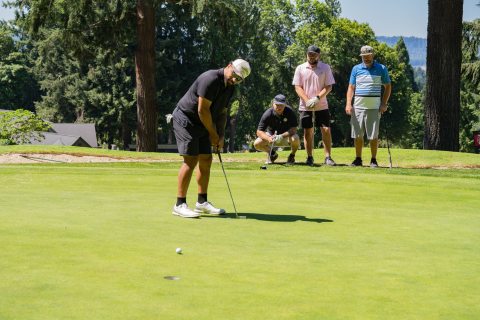 A man playing golf and lining up his shot
