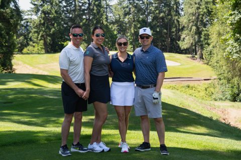 4 people smiling and looking at the camera at the st. john foundation golf tournament