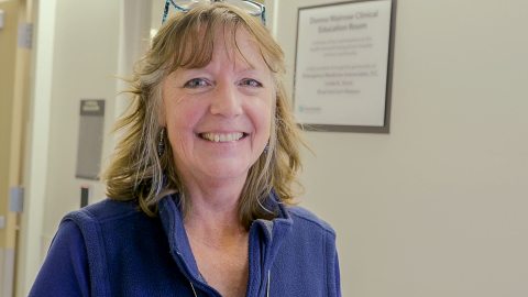 Photo of Donna wearing a blue top in a hallway