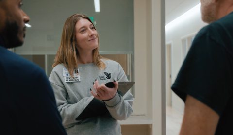 Community health hub employee listening to two individuals who only their shoulders are in frame