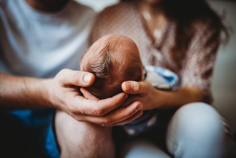 Back of baby's head while being held by family