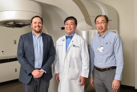 St. John medical team standing in front of new true beam linear accelerator