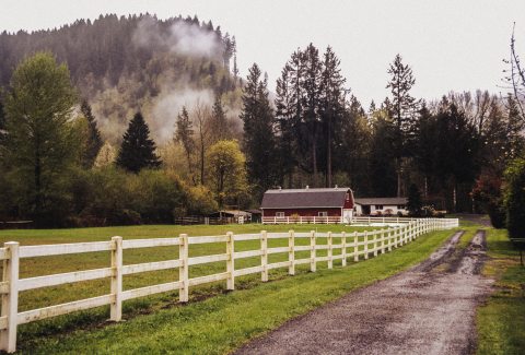 Rural setting with a farmhouse and barn and fenced in pasture