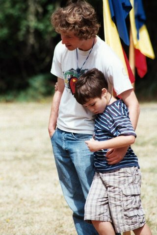 An older boy supporting a younger boy at camp