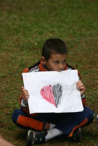 Child holding handmade drawing of a heart