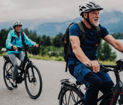 Two seniors riding bikes in a natural setting