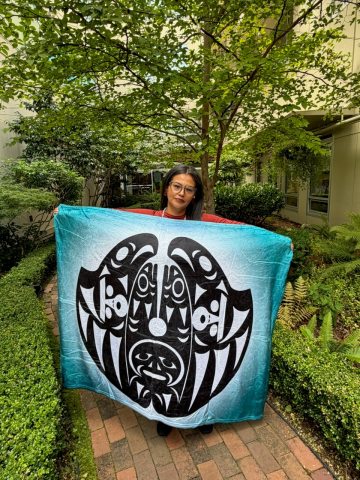Monica Revey displays a blanket with the program artwork
