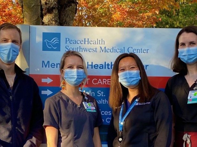 PGY2 residents pose in front of the Southwest Medical Center entrance sign with program leader Carolyn Wong.