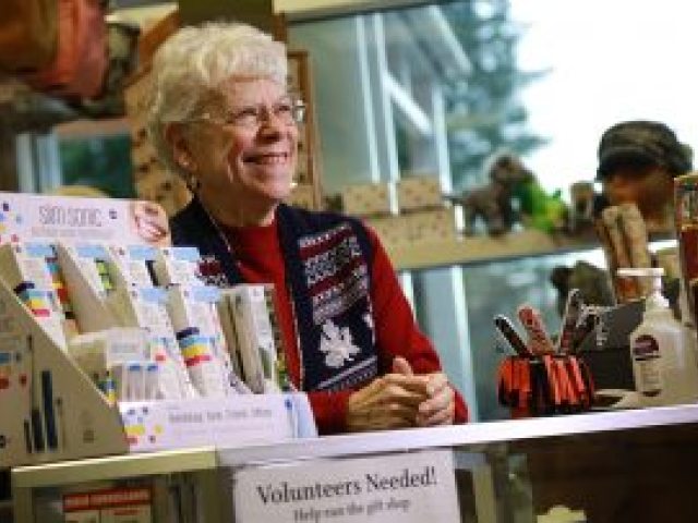 A smiling volunteer greets visitors from the Ketchikan Medical Center gift shop counter