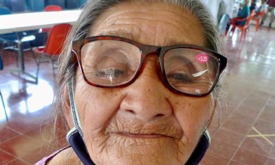 An older lady looking into the camera with her new eyeglasses