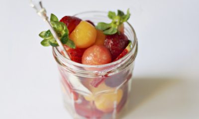 Small fruit salad in a clear cup on white background