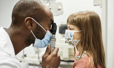 Eye doctor examines eyes of young child