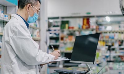 Pharmacy tech writes on clipboard
