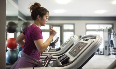 Woman working out on a treadmill at a gym.