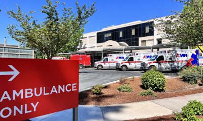 Emergency room parking lot with "Ambulance Only"  sign in the foreground and a row of ambulances in the background