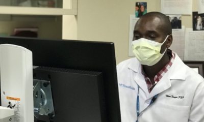 Titus Kosgei, DNP, works at a computer in the clinic