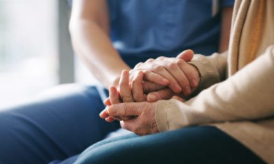 Close up of hands of medical caregiver giving comfort to a woman