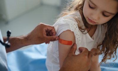 Little girl getting bandaid put on after vaccine.
