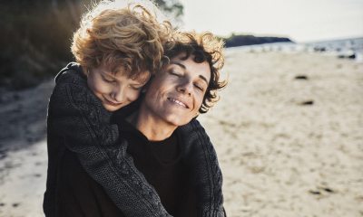 Child embracing a woman on a beach