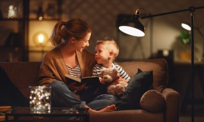 Mom and son reading a book under a light.