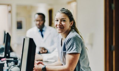 Nurse at computer with doctor in background