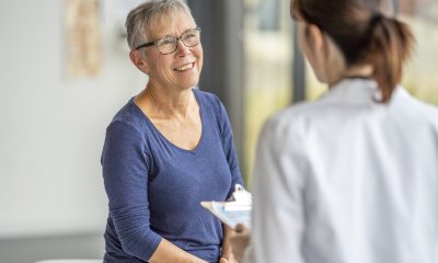 Older woman smiles as she talks with woman doctor