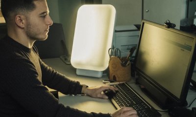 Man working at computer with happiness light next to him.