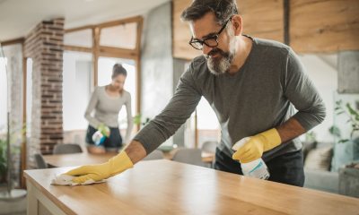 Two people wipe down counters in kitchen