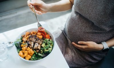 Close-up of bowl of healthy food in front of pregnant person