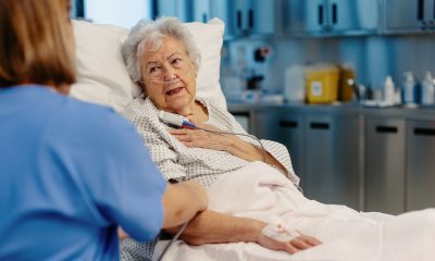 Nurse talks to a woman in a hospital bed