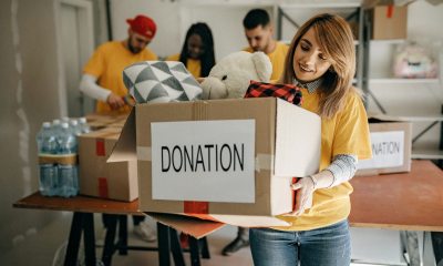 Woman carries a box marked with a sign donation